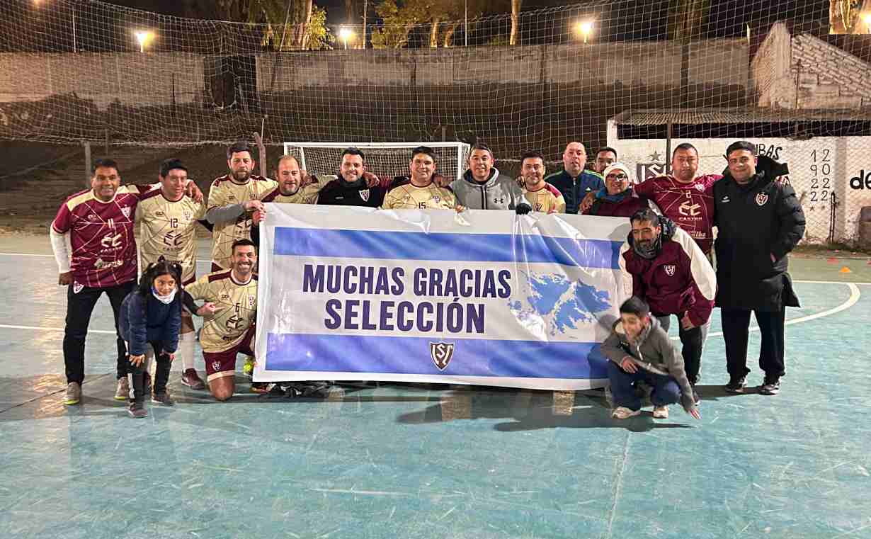 Equipo Senior de futsal de Sport club lujan de mendoza posando en la cancha de noche tras su victoria por 8 a 2 frente a Canon. Los jugadores y el cuerpo técnico sostienen una bandera que dice 'Muchas Gracias Selección' con el mapa de las Islas Malvinas.